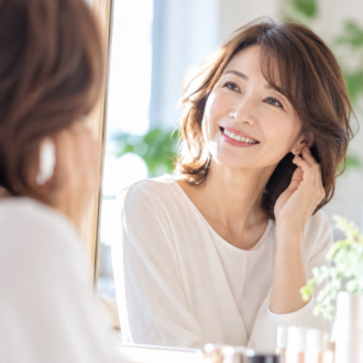 鏡を見ながら笑顔でおしゃれを楽しむ大人の女性